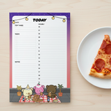 A cute cartoon-themed daily planner notepad with a purple and pink border, shown on a light wood tabletop next to a slice of pepperoni pizza on a white plate.